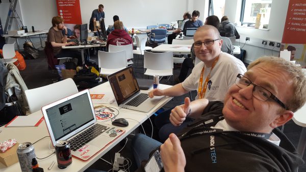 office room with two people on laptops and looking at the camera